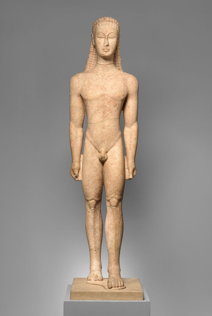 Frontal view of an ancient marble youth with patterned hair, arms at his sides and his left foot placed ahead