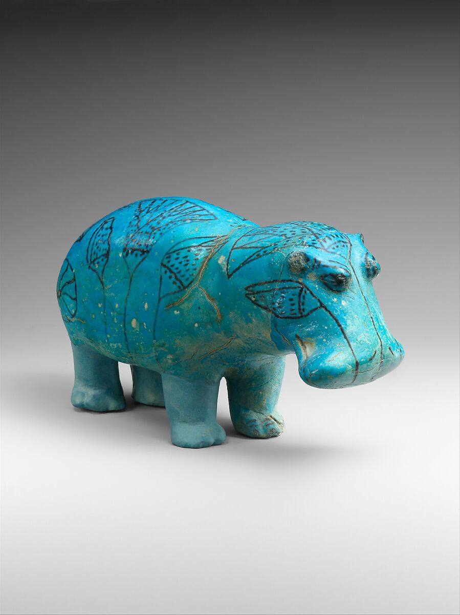 Blue faience hippopotamus with black lotus stems and flowers drawn across its broad body
